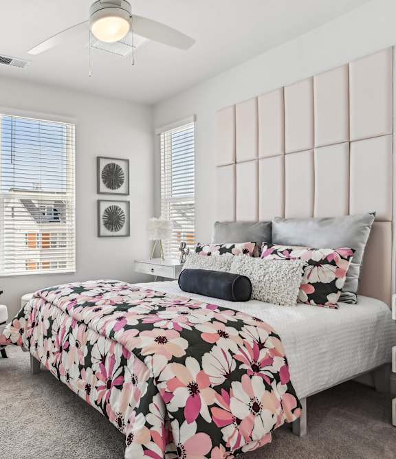 A bedroom with a bed, chair, and window.