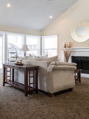 A cozy clubhouse living room with plush seating and a fireplace.