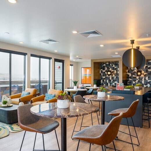 A modern living room with a kitchen area in the background.