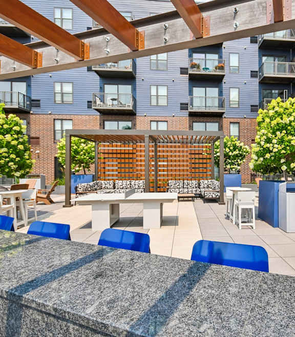 A modern outdoor seating area with blue chairs and tables.