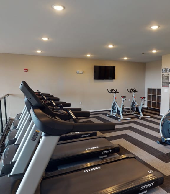 a gym with treadmills and other cardio equipment in a building