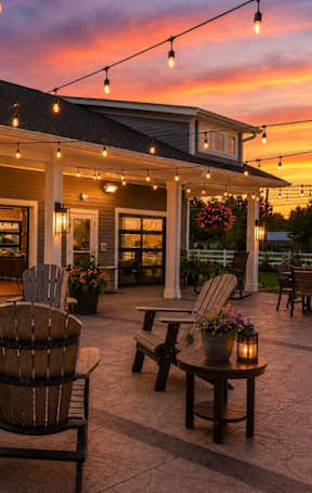 A cozy outdoor patio with wooden furniture and string lights.