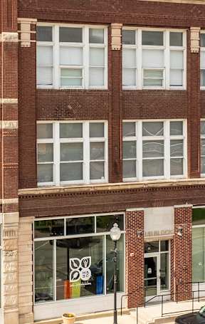 A large red brick building with a white arched window in the center.