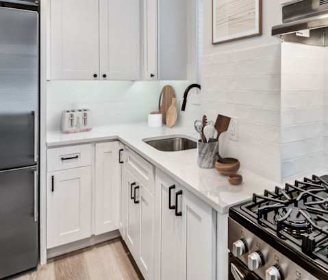 a white kitchen with a stove and a refrigerator