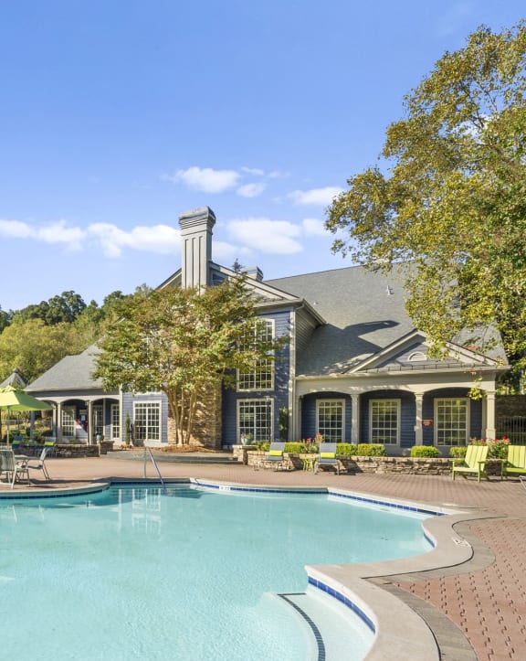 a large swimming pool with a house in the background