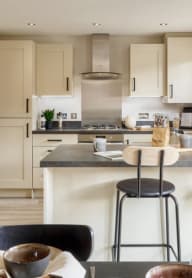 a modern kitchen with white cabinets and a dining area with a table and chairs