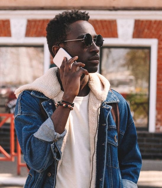 a man walking down the street talking on a cell phone