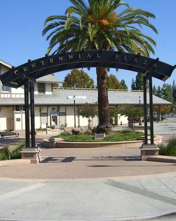 A sign that says Centennial Plaza is in front of a building.