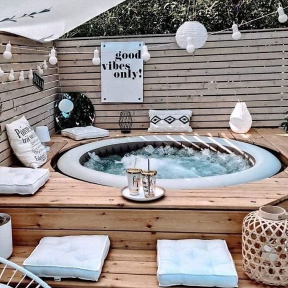 a jacuzzi with a canopy over it and a chair next to it