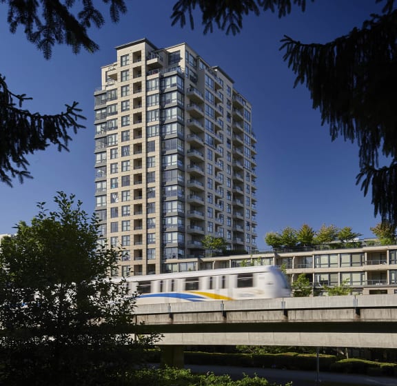 a tall white building with a train passing in front of it