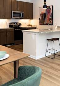 A kitchen with a table and chairs in front of it.