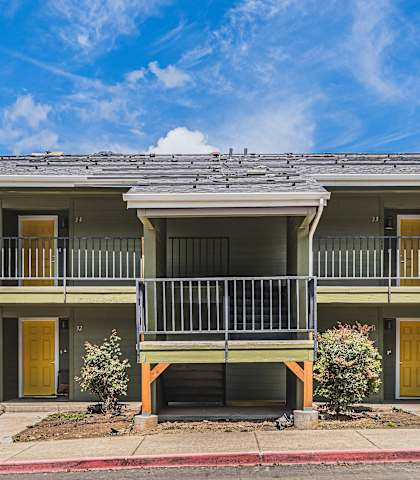 A two-story house with a balcony on the second floor.