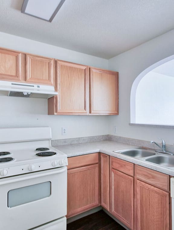 a kitchen with white appliances and wooden cabinets