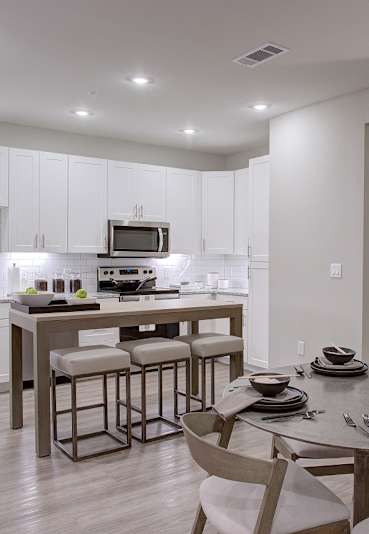 A modern kitchen with a dining table set for four.