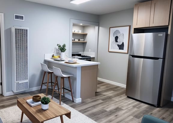 a kitchen with black cabinets and stainless steel appliances and a white counter top