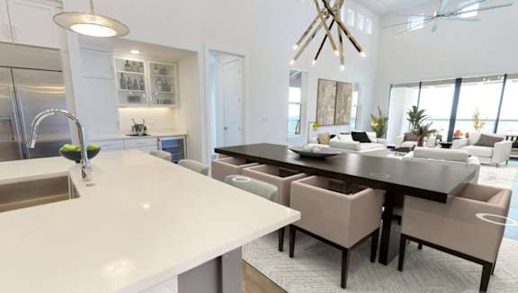 A modern kitchen with a large island and a dining area.