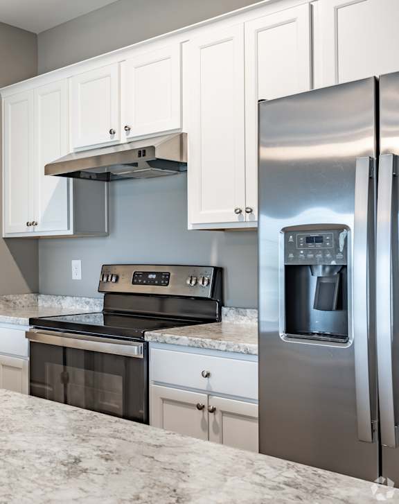 Kitchen with granite countertop and stainless steel appliances at Club Villas Apartments, Kathleen, GA
