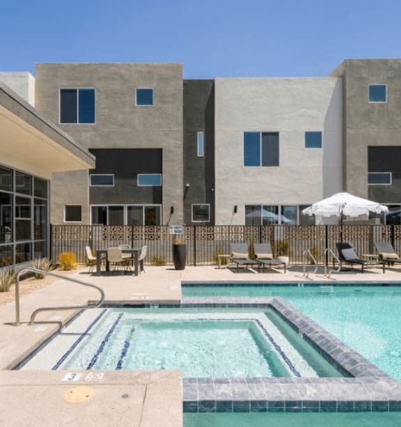 a swimming pool with chairs and a building in the background at Novella Biltmore, Phoenix, AZ