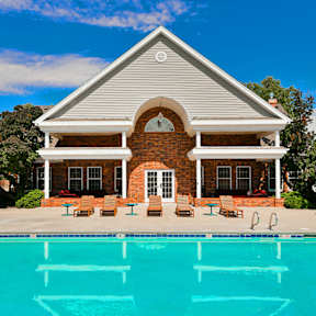 A house with a pool in front of it.