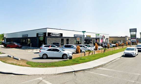 A street view image of a road with cars and buildings on the side.