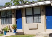 Thumbnail 2 of 21 - a house with two blue doors and a window