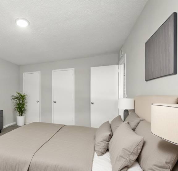 A bedroom with a large bed and a flat screen TV mounted on the wall.