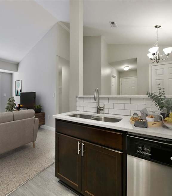 A modern kitchen with a beige couch and a stainless steel dishwasher.