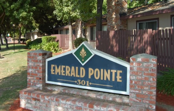 a sign for emerald point in front of a house