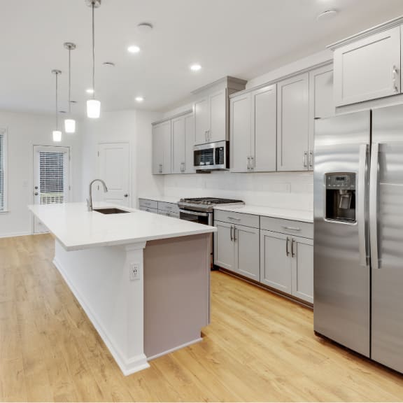 a large kitchen with white cabinets and stainless steel appliances