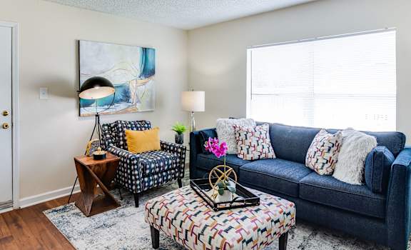 a living room with a blue couch and two chairs