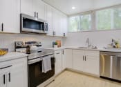 Thumbnail 13 of 17 - a kitchen with white cabinets and stainless steel appliances