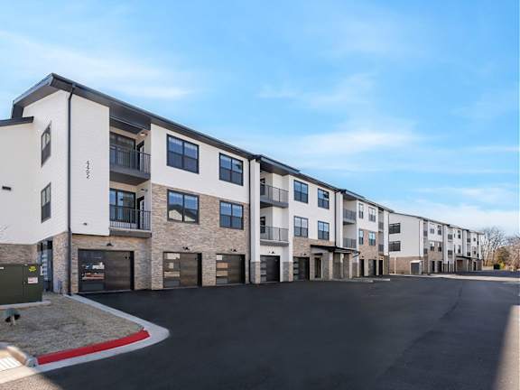 A row of modern townhouses with garages and driveways.