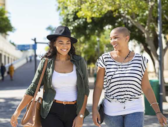 two women walking down a street holding hands