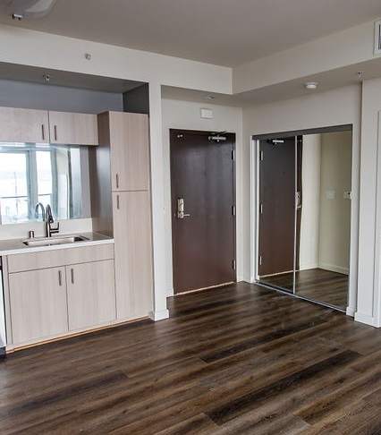 A room with a desk, chair, and shelves with various items on them.
