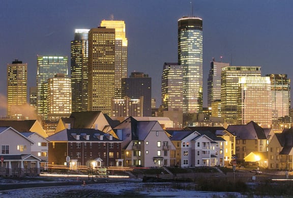 a city skyline at night with town-houses at Heritage Park Apartments and Townhomes in Minneapolis, MN