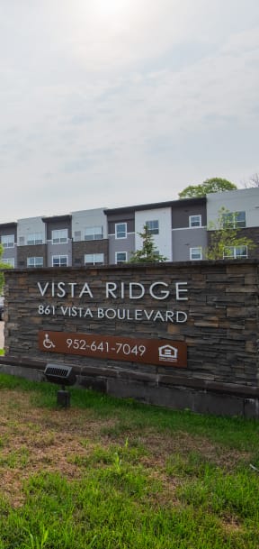 a large sign sits in front of an apartment building