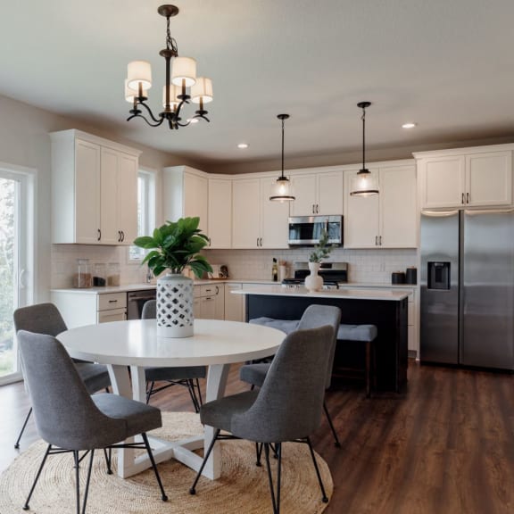 a kitchen and dining room with a table and chairs