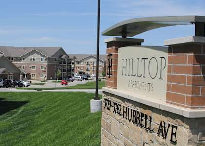 The image shows a sign for Hilltop Apartments on Hubbell Ave.