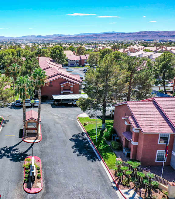 A sunny day in a residential neighborhood with houses and palm trees.
