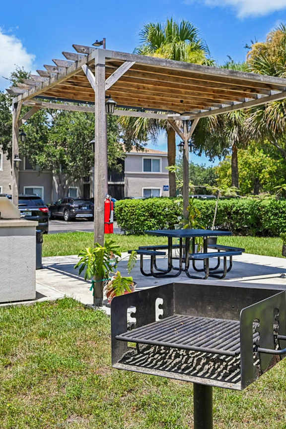 A park with a bench and picnic table under a wooden canopy at Heritage Bay, Jensen Beach, 34957