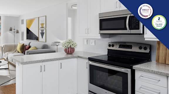 A modern kitchen with white cabinets and a black stove top oven.