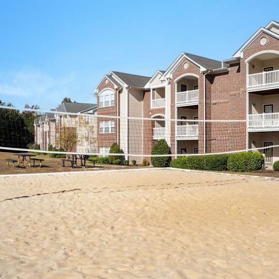 A large building with a pool in front of it at Village on the Lake Apartments, Spring Lake, 28390