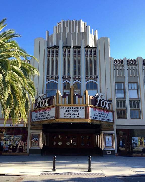 A palm tree stands in front of a building with a sign that says "Fox".