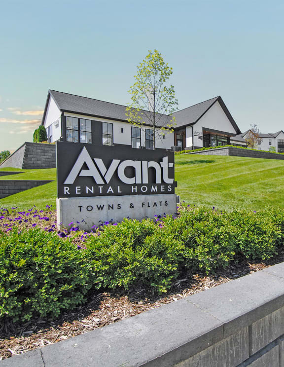 a view of the avanti rental homes sign in front of a grassy yard