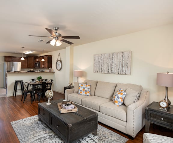 A living room with a couch, coffee table, and a ceiling fan.