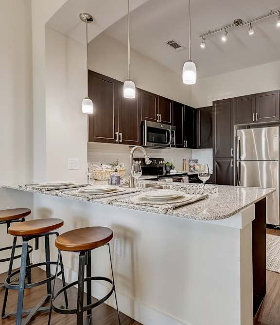 A kitchen with a bar area and stools.