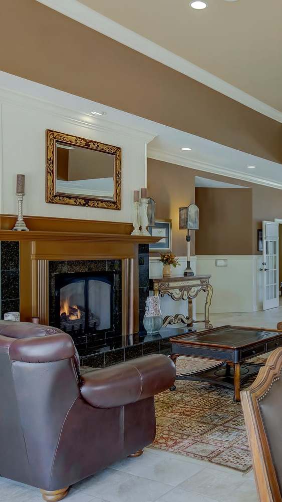 A modern living room with a grey sofa, a coffee table, and a painting on the wall.