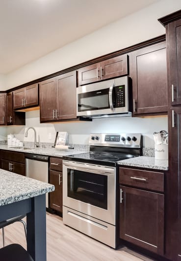 kitchen with espresso cabinetry and accent island at Lake Jonathan Flats community