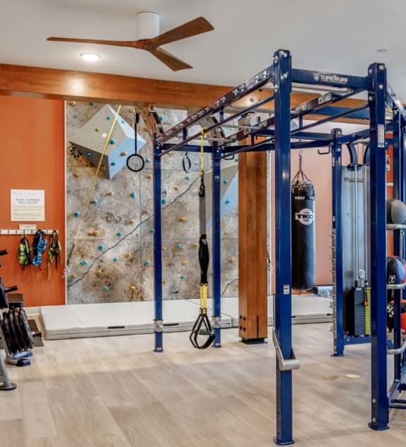 a gym with weights and exercise equipment and a stone wall