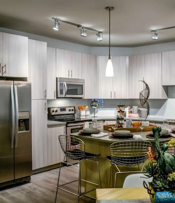 A modern kitchen with a large island and a refrigerator.